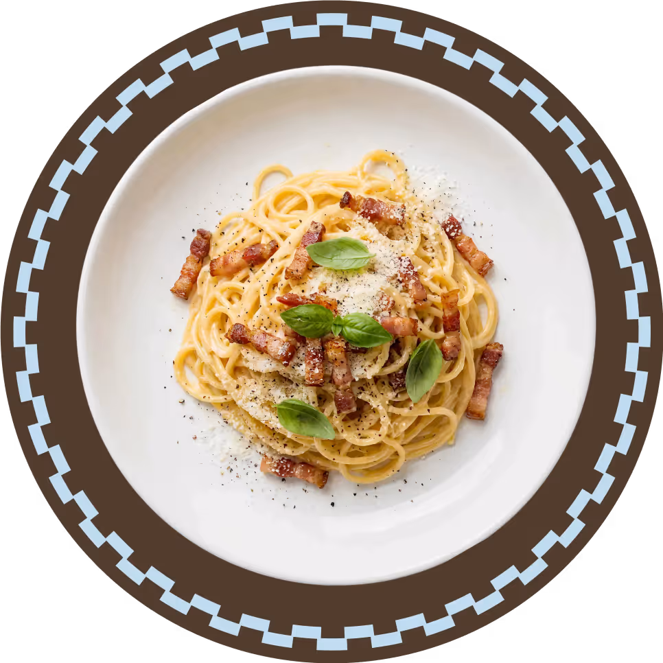 Bord met spaghetti carbonara gegarneerd met spekjes, Parmezaanse kaas, zwarte peper en basilicumblaadjes.