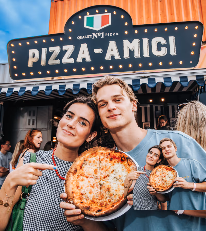 Een glimlachend jong stel toont een pizza buiten pizzeria Fornello met een bordes en Italiaans vlaglogo.